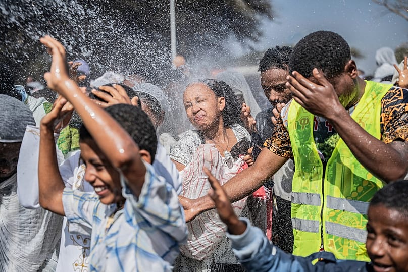 Holy water is sprayed on Ethiopian Orthodox worshippers, during the celebration of the Ethiopian Epiphany on lake Dembel, in Batu, Ethiopia, Monday, Jan. 19, 2026.