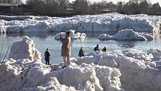 Eine Frau fotografiert entstehende Eisberge an den Ufern der Elbe in Deutschland. Aufgenommen am 19. Januar 2026.