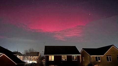 The aurora borealis illuminates the cloud cover over Rushmere St. Andrew, Ipswich, England, Monday, Jan. 19, 2026. (Joe Pickover/PA via AP)