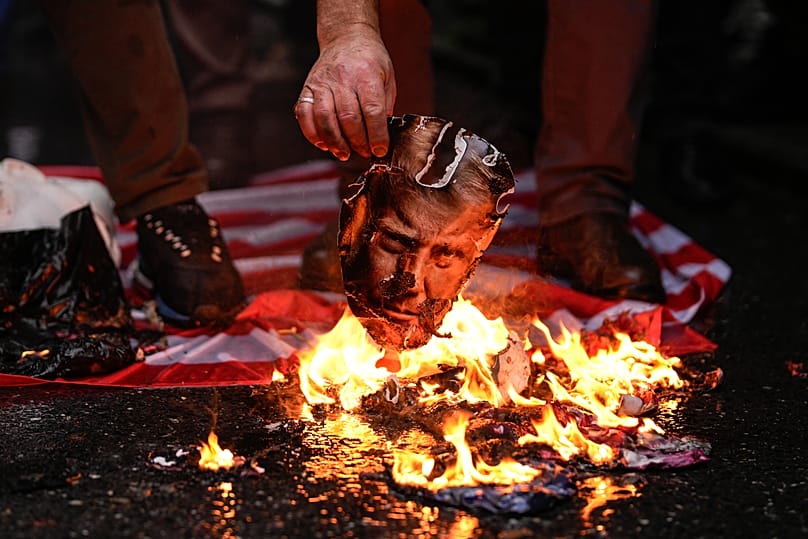 A man burns a photograph of US President Donald Trump during an anti-US rally in Istanbul, 18 January, 2026