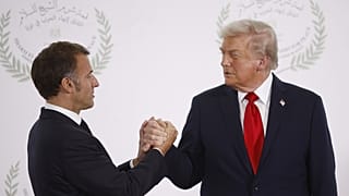 الرئيس دونالد ترامب والرئيس الفرنسي إيمانويل ماكرون يتصافحان في القمة الدولية للسلام في غزة، بشرم الشيخ، مصر، 2025