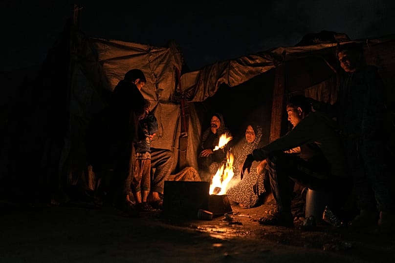 Vertriebene Palästinenser wärmen sich an einem Feuer in einem Zeltlager in Gaza-Stadt, 18. Januar, 2026