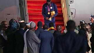 Kalidou Koulibaly uçaktan inerken Afrika Uluslar Kupası'nı elinde tutuyor