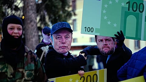 FILE - People with Elon Musk masks attend a demonstration against US President Donald Trump at the World Economy Forum in Switzerland. 18 January 2026