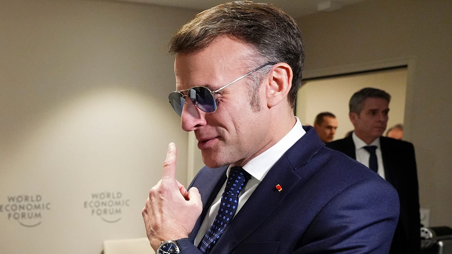 Emmanuel Macron montre ses lunettes au Premier ministre canadien Mark Carney, à Davos, le 20 janvier 2026.