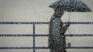 شخص يحتمي من المطر يوم الأربعاء 4 يناير 2023 في لوس أنجلوس. (سارة راينغوييرتز/ صحيفة أورانج كاونتي ريجستر عبر أسوشيتد برس)