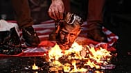 A man burns a photograph of US President Donald Trump during a rally in support of the Iranian government in Istanbul, 18 January, 2026
