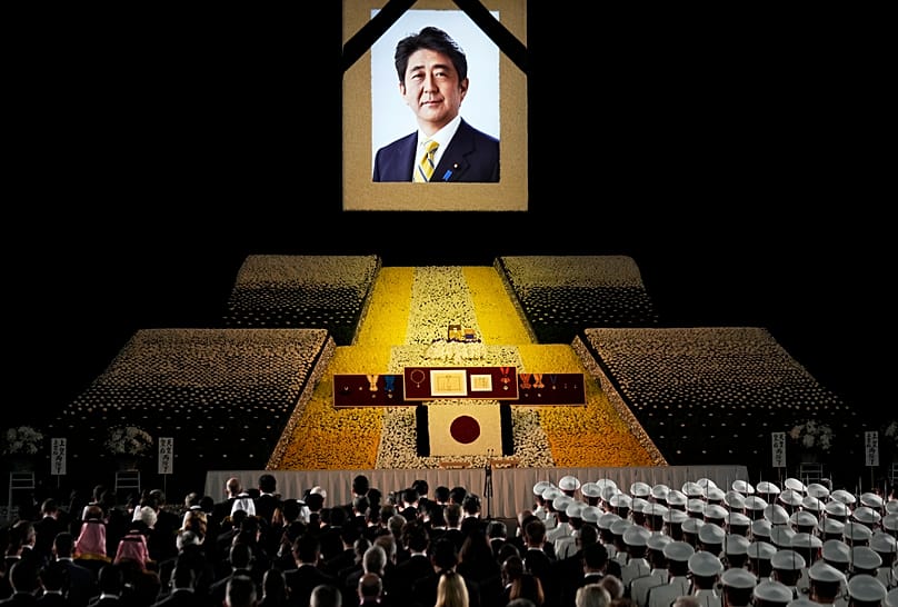 Um retrato do antigo Primeiro-Ministro japonês Shinzo Abe é pendurado no palco durante o seu funeral de Estado em Tóquio, a 27 de setembro de 2022
