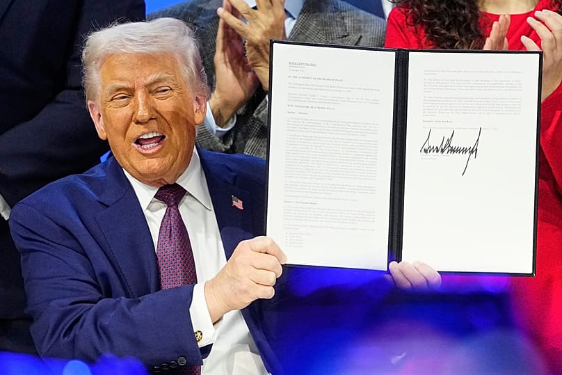US President Donald Trump holds the charter during a signing ceremony on his Board of Peace initiative at Davos, 22 January 2026
