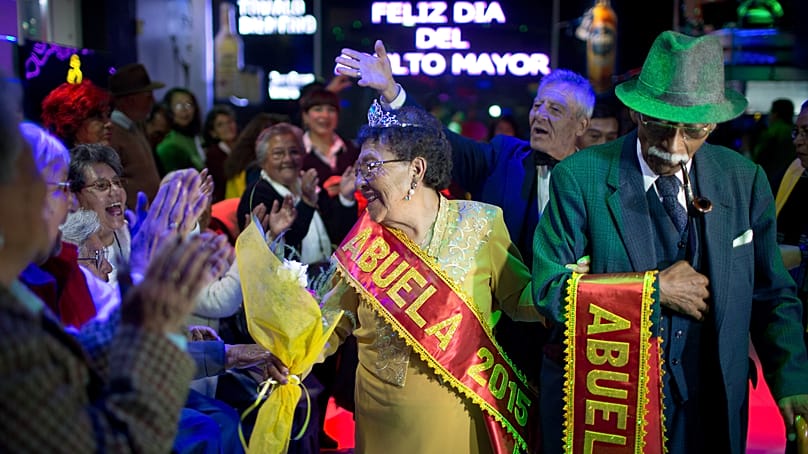 Adela Loayza (75 lat), w środku, i David Luna (72 lata), po prawej, witają tłum po koronacji na „Dziadków La Paz 2015” w La Paz w Boliwii, w środę 26 sierpnia 2015 r.