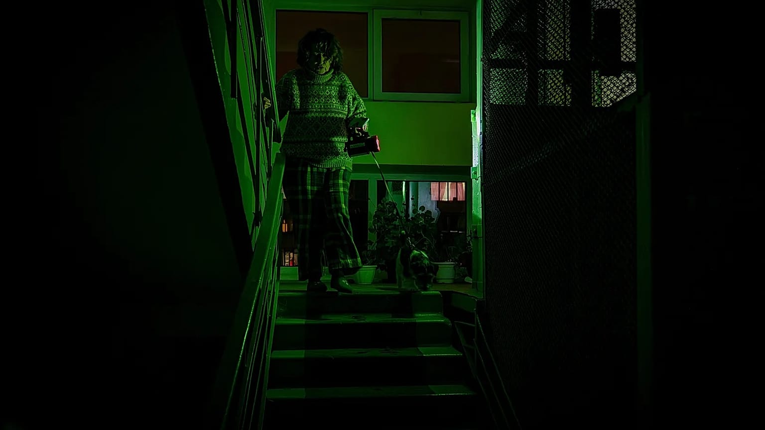 A woman goes to see her neighbour during a blackout in Kyiv, 13 January, 2026