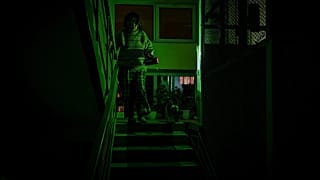 A woman goes to see her neighbour during a blackout in Kyiv, 13 January, 2026