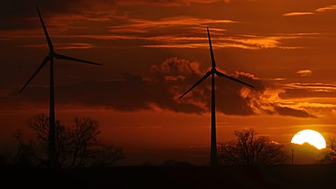 The sun sets behind wind turbines near Pokrent, northern Germany, Friday, Nov. 17, 2017. 