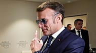 French President Emmanuel Macron points to his glasses as he arrives at a meeting with Canadian PM Mark Carney at the World Economic Forum in Davos, 20 January 2026