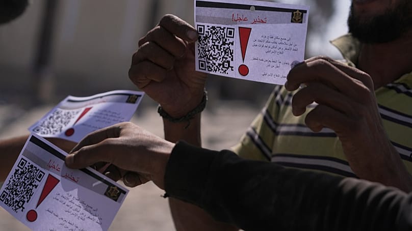 Palästinenser zeigen Flugblätter, die von einer israelischen Drohne abgeworfen wurden und die Menschen warnen, 20. Oktober 2025