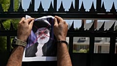 A defaced poster of Ayatollah Ali Khamenei is placed by a demonstrator on a gate of Iran's embassy in Santiago, 20 January, 2026