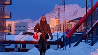 A woman walks on a street at sunset in Nuuk, Greenland, on Wednesday, Jan. 21, 2026.