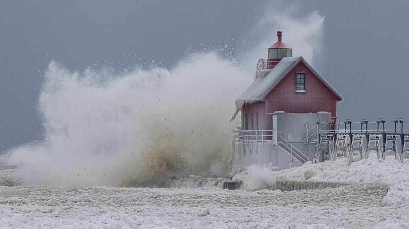 Большая волна озера Мичиган подбрасывает в воздух шары льда, ударяясь о маяк South Pierhead Outer Light в Гранд-Хейвене, штат Мичиган, понедельник, 19 января 2026 года.