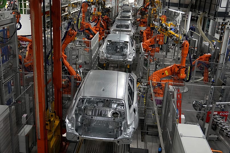 Robots work on cars of German car manufacturer BMW at an assembly line in Munich, 22 October, 2021