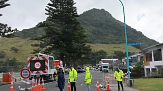 Emergency workers attend the scene after a landslide hit a campground at Mt. Maunganui, New Zealand