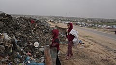 تجمع فتيات فلسطينيات مواد بلاستيكية وورقية لحرقها من أجل الطهي والتدفئة، في مكبّ نفايات بمدينة خان يونس جنوبي قطاع غزة، الخميس 22 كانون الثاني/يناير 2026.