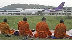 Mönche schauen auf ein Flugzeug, Thailand