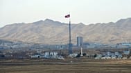 North Korea's flag flies on a tower high above the village of Ki Jong Dong, 25 March, 2012