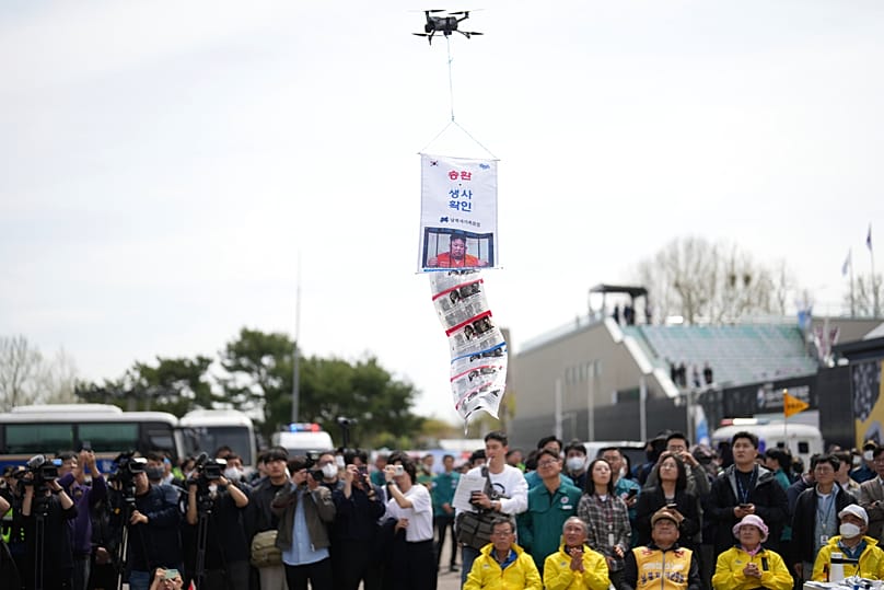Members of the Abductee's Family Union demonstrate the flying of leaflets carried by a drone near the Unification Bridge, 23 April, 2025