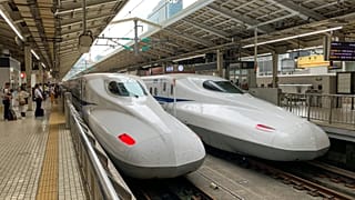 Deux trains à grande vitesse blancs dans une gare de Tokyo, au Japon