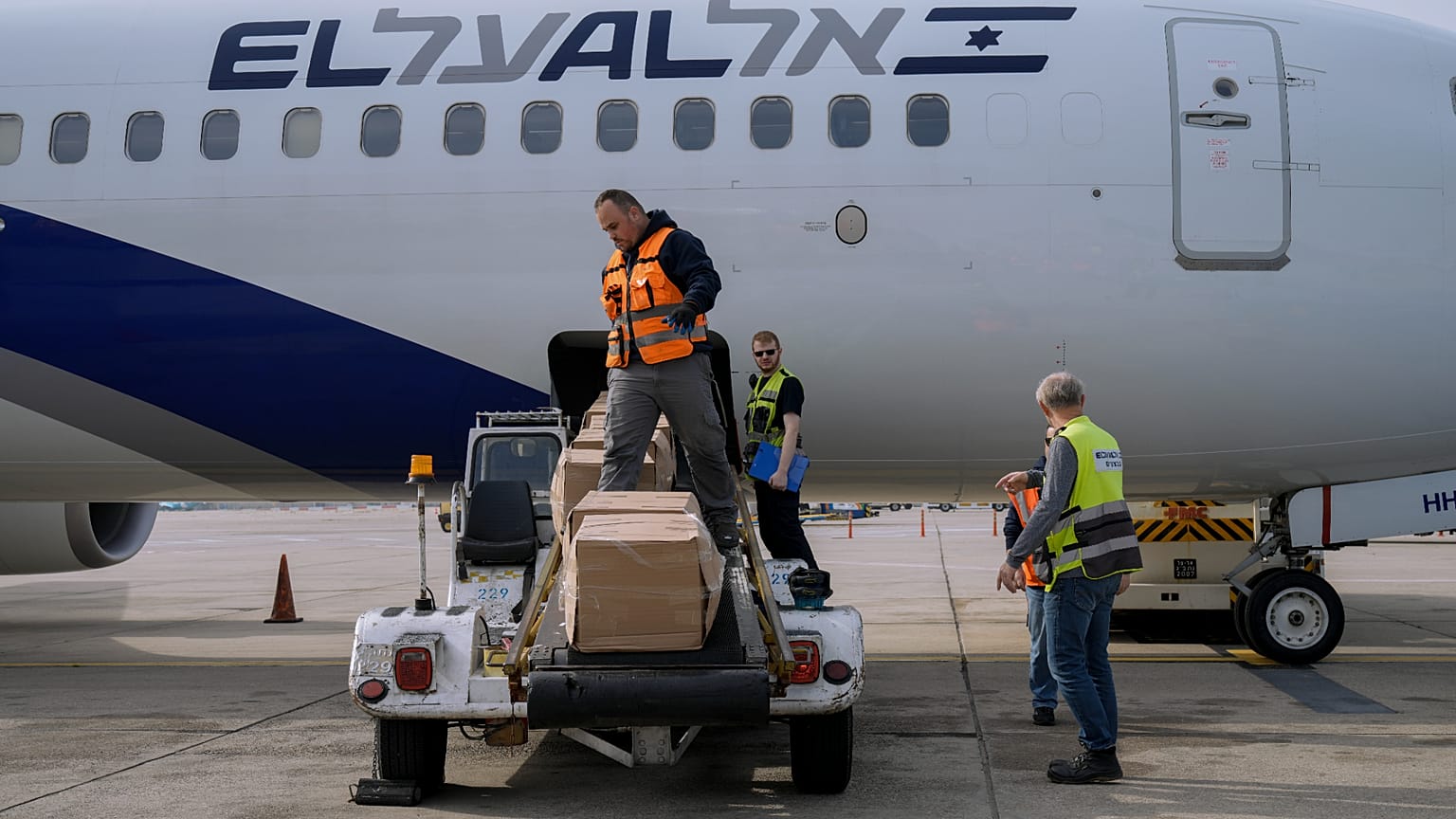 عمالٌ يُحمّلون طرودًا من المساعدات الإنسانية الإسرائيلية لمساعدة المتضررين من القتال في أوكرانيا، في مطار بن غوريون بمدينة اللد الإسرائيلية، يوم الثلاثاء 1 مارس/آذار 2022. وقد