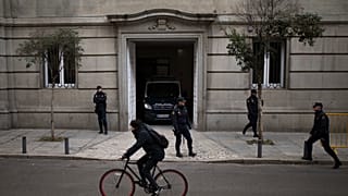 يقف ضباط الشرطة الوطنية الإسبانية حراساً بينما تغادر سيارة شرطة المحكمة العليا في مدريد، يوم الجمعة 1 ديسمبر/كانون الأول 2017. ومن المقرر أن يبتّ قاضٍ في المحكمة العليا الإسبا