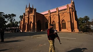 يقف شرطي حارساً خارج كاتدرائية القديس يوحنا، حيث يحضر المسيحيون قداس عيد الميلاد، في بيشاور، باكستان، يوم الخميس 25 ديسمبر 2025. (صورة من وكالة أسوشيتد برس/محمد سجاد)