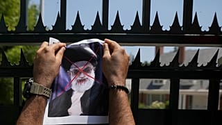 A defaced poster of Ayatollah Ali Khamenei is placed on a gate of Iran's embassy, during a rally in support of anti-government protests in Iran, in Santiago, 20 January 2026