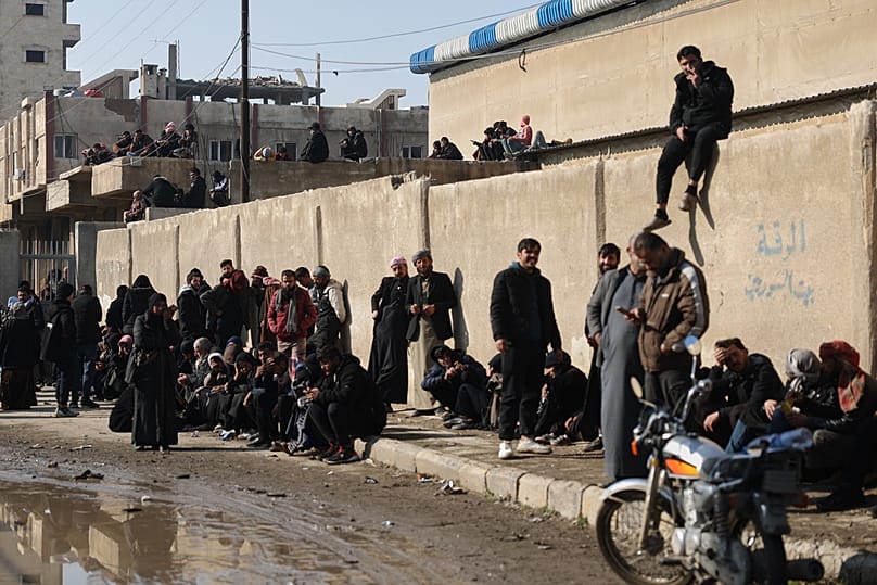 عائلات سورية تنتظر أمام المحكمة الإفراج عن أطفالها المحتجزين في سجن "الأقطان" في الرقة، بعد انسحاب قوات سوريا الديمقراطية، في 25 يناير 2026.