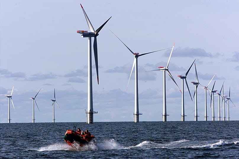 A speed rubber-boat passes along the over all 110 meters high offshore wind mills set up in the North Sea, 14km west of the small village of Blavand near Esbjerg, Denmark.