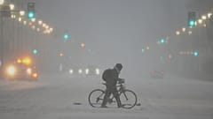Une personne poussait un vélo pendant une tempête hivernale à Philadelphie, le dimanche 25 janvier 2026.