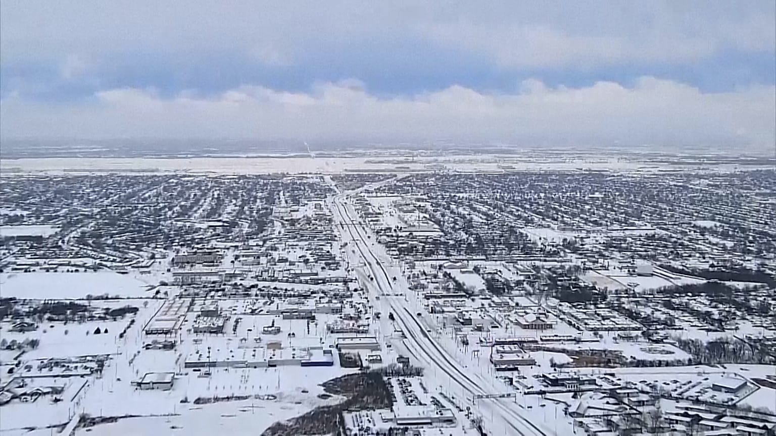 Aerial footage shows a snow-covered Oklahoma City, snow plows at work