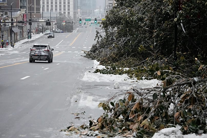 Ice covered tree limbs block a lane of traffic along West End Ave. during a winter storm Sunday, Jan. 25, 2026, in Nashville, Tenn.