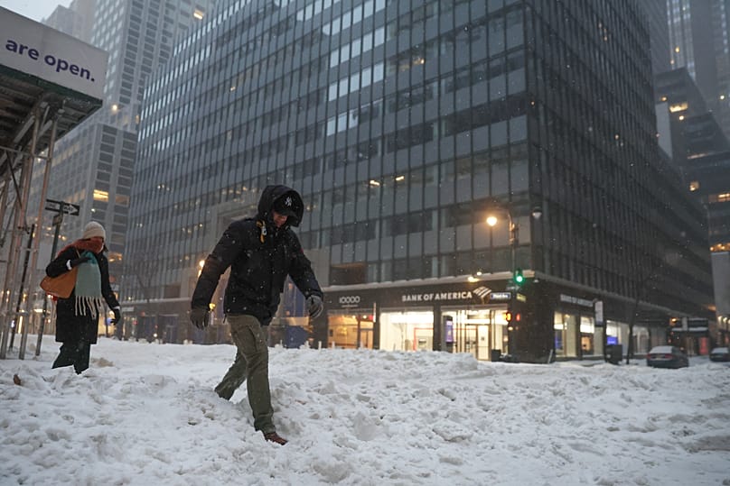 Pedestrians cross the street during a winter storm, Sunday, Jan. 25, 2026, in New York. 