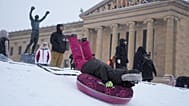 People sled at Philadelphia Art Museum steps during a winter storm in Philadelphia, Sunday, Jan. 25, 2026.