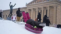 Auf den Stufen des Philadelphia Museum of Art rodeln Menschen. Ein Wintersturm trifft Philadelphia am Sonntag, 25. Januar 2026.