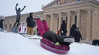 People sled at Philadelphia Art Museum steps during a winter storm in Philadelphia, Sunday, Jan. 25, 2026.