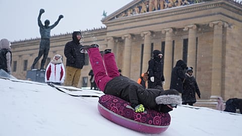 Personas se deslizan en trineo por las escaleras del Museo de Arte de Filadelfia durante una tormenta de invierno el domingo 25 de enero de 2026.