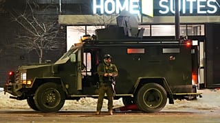 A federal agent stands guard near a hotel during a noise demonstration protest in response to federal immigration enforcement operations in Minneapolis, 26 January 2026