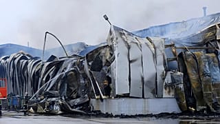 A firefighter sprays water after an explosion and fire at a cookie factory in Trikala, 26 January, 2026