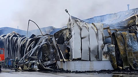 A firefighter sprays water after an explosion and fire at a cookie factory in Trikala, 26 January, 2026