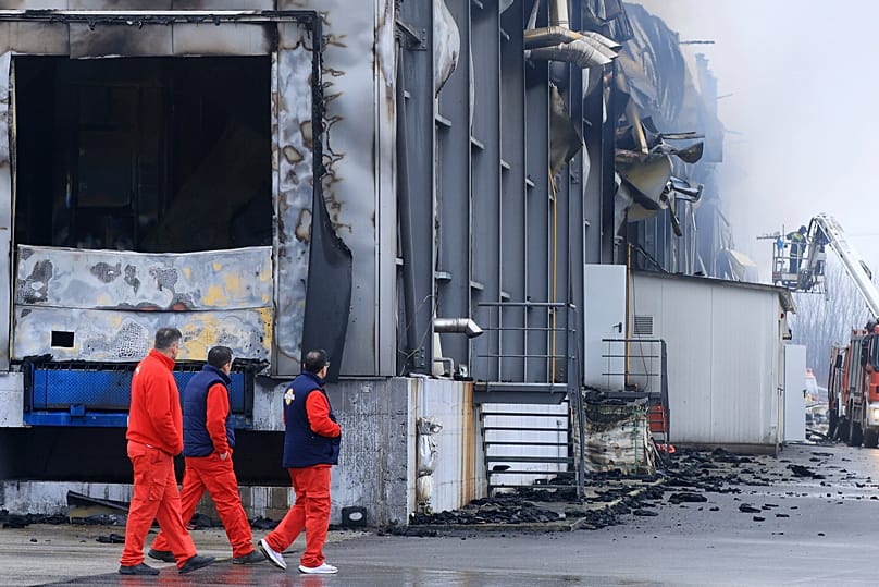 Fire crews walk past the cookie factory in Trikala, 26 January, 2026