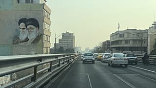 تمر المركبات أمام صورة مؤسس الثورة الإيرانية الراحل آية الله الخميني (يسار) والمرشد الأعلى آية الله علي خامنئي، في وسط مدينة طهران، إيران، الأحد 25 يناير 2026. (صورة من وكالة 