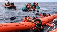Migrants who fell in the water struggle to cling on to a float before being rescued by humanitarian rescuers in the Mediterranean Sea, 18 October, 2021