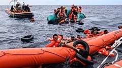 Migrantes que caíram à água lutam para se agarrarem a uma boia antes de serem resgatados por socorristas humanitários no Mar Mediterrâneo, 18 de outubro de 2021